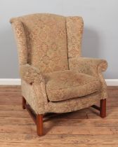 A wing back arm chair raised on square cut legs.