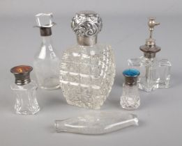 A collection of silver topped scent bottles including cut glass example.