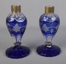A pair of blue glass vases featuring grape vine design with silver plated mounts. Both pieces are