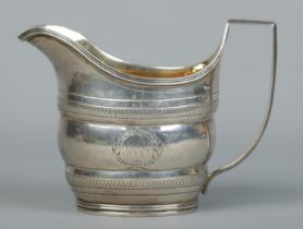 A George III silver cream jug with engraved decoration and gilt interior. Assayed London 1801 by