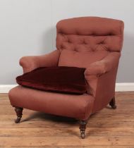 A Victorian arm chair raised on turned mahogany supports. Having Hampton & Sons castors. Height of