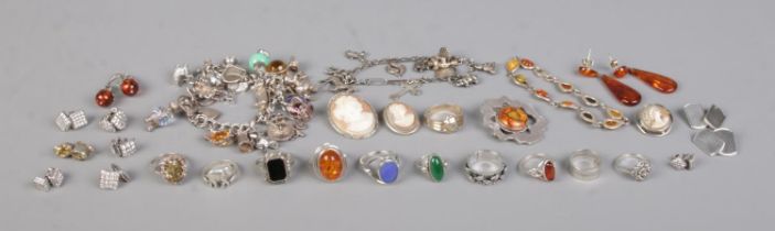 A collection of silver and white metal jewellery. To incude charm bracelets, cameo brooches, dress
