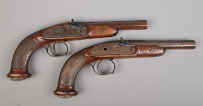 A pair of 19th century percussion pistols. Having chequered walnut grips and damascus octagonal