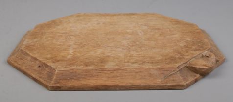Robert 'Mouseman' Thompson, an oak cheese board with signature mouse carving. 31cm x 26cm.