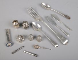 A good collection of silver including various cutlery, thimbles, salt & pepper shaker, pencil