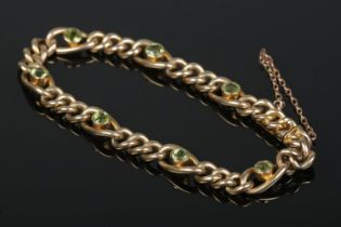 A 9ct gold bracelet set with emerald coloured stones. 12.44g.