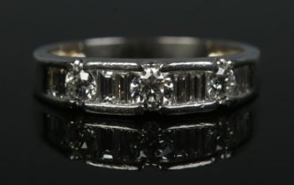 A platinum and diamond ring. Channel set with eight baguette and three brilliant cut diamonds.