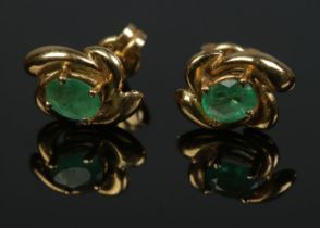 A pair of 18ct gold and emerald stud earrings. Total weight 1.3g.