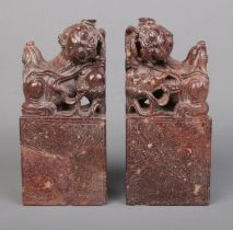 A pair of Chinese carved hardstone bookends modelled as Dog of Fo/Temple Lions raised on plinths.