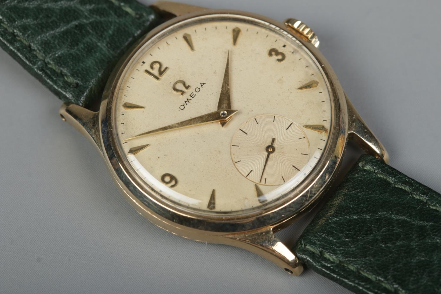 A gents 9ct gold Omega manual wristwatch. Having subsidiary seconds and baton and Arabic numeral