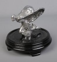 A kneeling Spirit of Ecstasy Rolls Royce car mascot mounted on oriental wooden stand. Approx. height