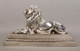 A silverplated bronze sculpture of a lion raised on stepped plinth. Height 16cm, Length 28.5cm.