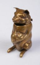A novelty brass vesta case in the form of a seated pig holding a bag of money.