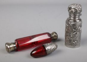 A ruby coloured glass double ended scent bottle with silver top to either side together with similar