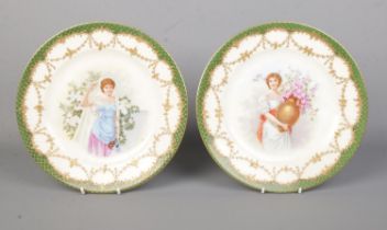 A pair of Vienna porcelain plates. With scenes depicting maidens with flowers and having green and