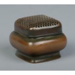 A Chinese bronze hand warmer of square form, having pierced cover. Character marks to base. 5.5cm