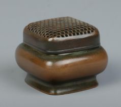 A Chinese bronze hand warmer of square form, having pierced cover. Character marks to base. 5.5cm