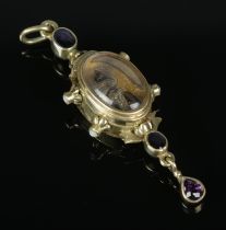 A yellow metal pendant fob watch of unusual form set with two opal stones to each side and purple