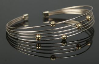 A 9ct white and yellow gold five band bangle. 7.58g.