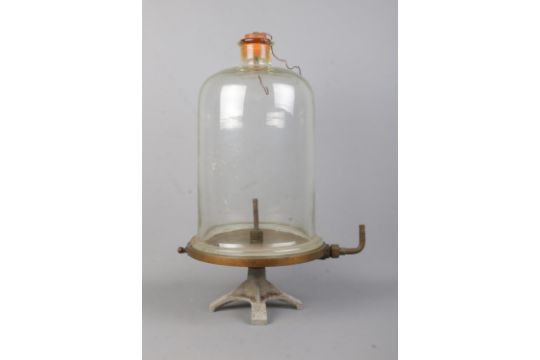 A antique vacuum pump plate and bell jar. glass dome has some damage to the rim.