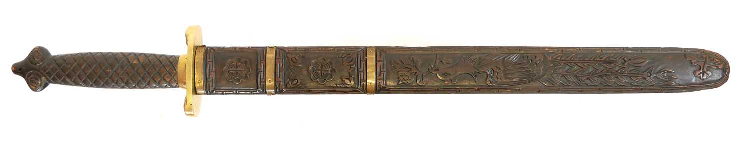 Chinese double edged sword, with copper studded blade, brass guard and carved grip and scabbard.