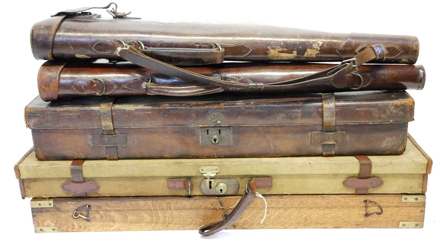 Five gun cases, to include an oak and brass case (no interior) a canvas and leather case, an all