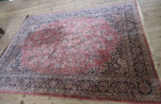 A modern rug, decorated with flowers and scrolling leaves to a peach ground, 80ins x 110ins