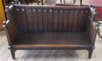An Arts and Crafts style child's oak settle, with carrying handles and supports in the gothic style,
