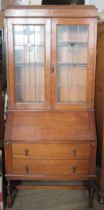 An oak bureau bookcase, with leaded glass decoration, height 79ins, width 34ins