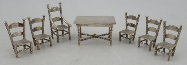 A Dutch silver miniature dining table, and chairs, to include one carver and five single chairs with