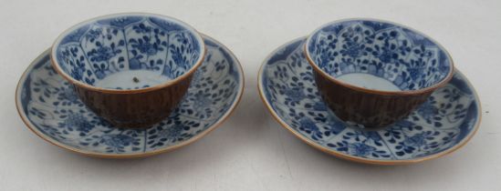 Two Chinese porcelain café au lait tea bowls and saucers, decorated with blue and white flowers