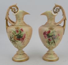 A pair of Royal Worcester blush ivory ewers, decorated with roses, with scrolling handles, shape
