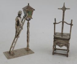 Two Dutch silver miniature models, a figure up a ladder lighting a street lamp and a book press