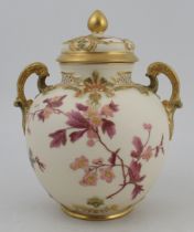 A Royal Worcester spherical glided ivory two handled covered vase, with pierced neck and decorated