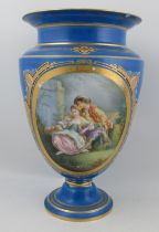 A Continental porcelain pedestal vase, decorated with an oval panel of figures seated in a garden