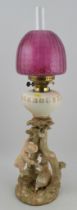 A Royal Worcester blush ivory oil lamp, modelled with Kate Greenaway figures, shape No. 1240, with