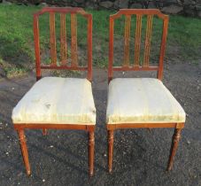 A pair of Edwardian salon chairs, with three bar slat backs, with carved oval flower panels,