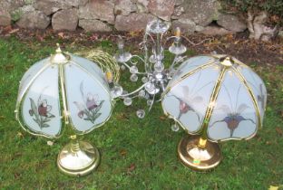 Two brass coloured table lamps, a chrome and glass hanging light fitting and a wire work shade