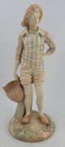 A Royal Worcester Hadley figure, of man in a stripped tunic top, holding a wicker basket, shape No