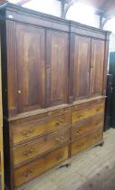 A large antique oak house keepers cupboard  having two double doors to the top flanked by reeded