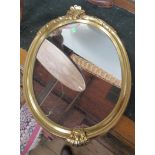 A small oval gilt framed wall mirror