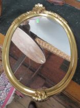 A small oval gilt framed wall mirror