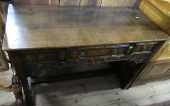 A reproduction oak side table, fitted with drawers over a carved frieze, width 45ins x 19ins, height