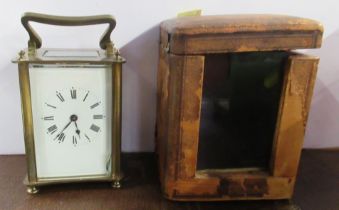 A brass carriage clock, with leather covered travel case