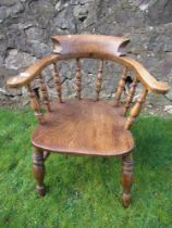 An elm captains chair, with turned spindle back