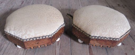 A pair of Victorian walnut and upholstered octagonal foot stools, raised on porcelain feet