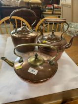 Three copper kettles, one in the style of Christopher Dresser