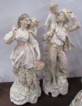 A pair of 19th century Continental porcelain figures, man and a woman, both holding children, height