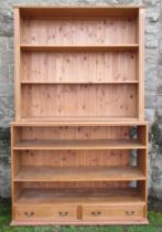 A pine double bookcase, fitted with two drawers to the base, width 54ins, depth 16ins, height 84ins