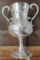 A Victorian silver two handled trophy cup, with embossed decoration and presentation inscription,